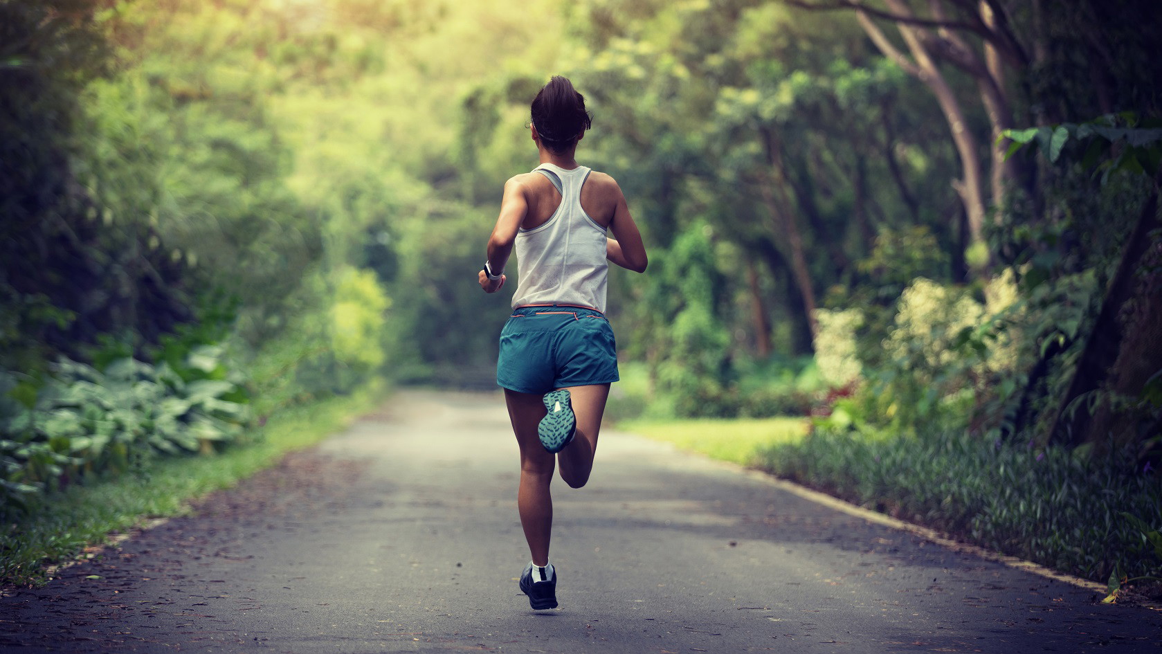 A woman on a soring run through a forest landscape 