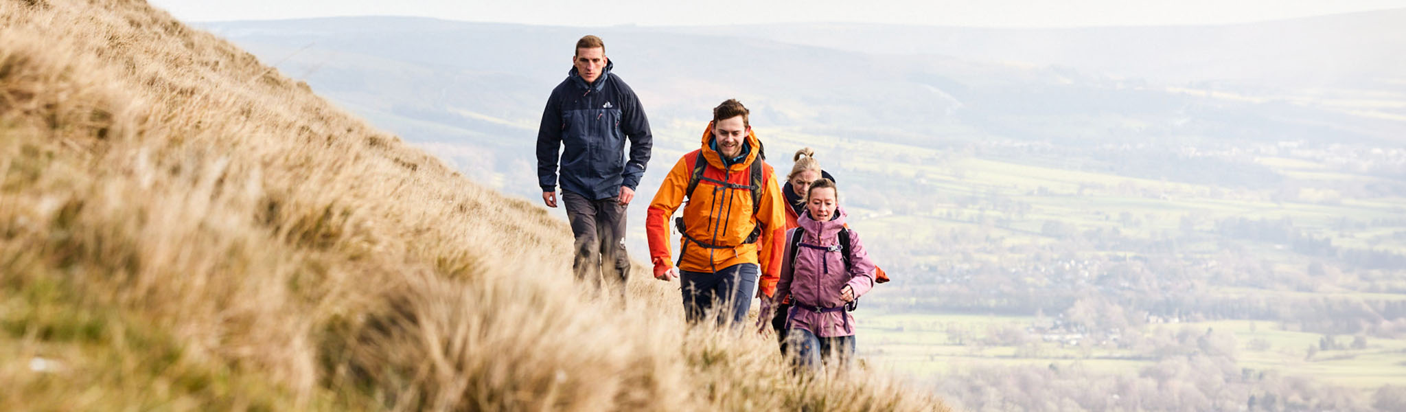 A group of 4 people running on a hill