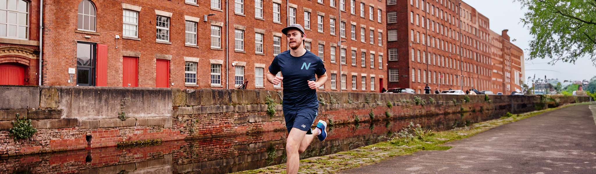 A man running past some houses in running clothes